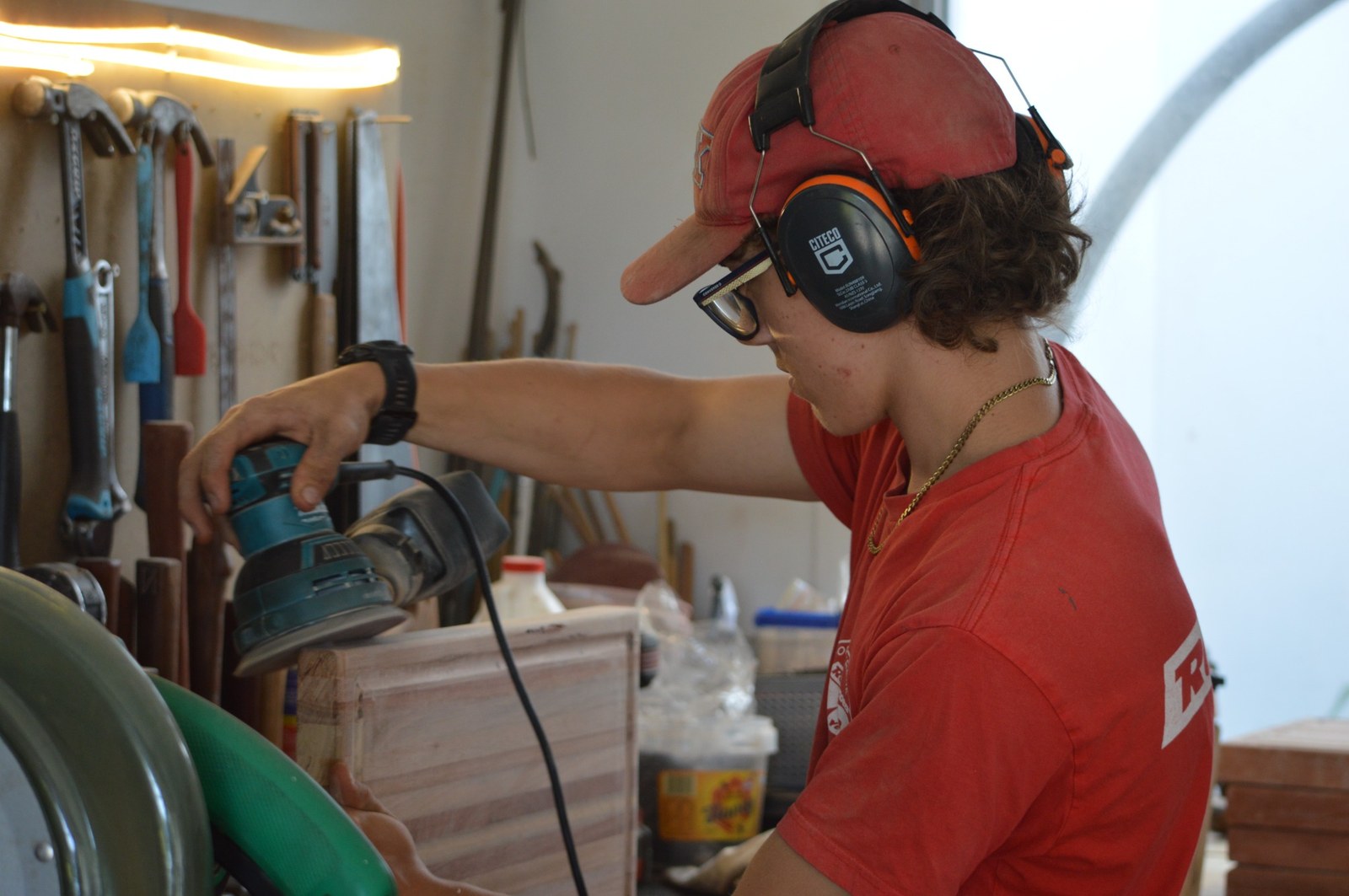 Noah sanding a chopping board in the workshop